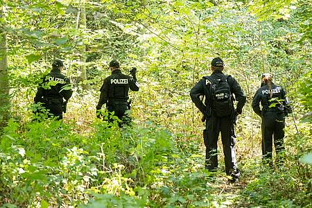 Polizisten durchsuchen im August 2022 ein Waldstück nach Spuren und Gegenständen.