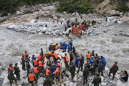Rettungskräfte in der südwestchinesischen Stadt Moxi bauen eine Brücke, um Dorfbewohner nach dem Erdbeben über einen Fluss zu bringen.