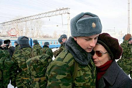 Ein junger Rekrut, der zum Militärdienst einberufen worden ist, umarmt vor der Abreise in die westsibirische Stadt Kemerowo seine Mutter.