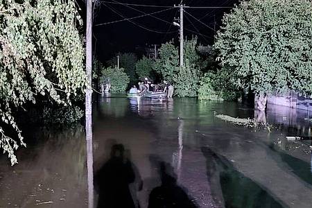 Retter helfen Menschen bei der Flucht aus einem überschwemmten Gebiet, nachdem ein russischer Raketenangriff den Damm eines Stausees in der Nähe von Krywyj Rih, dem Geburtsort von Präsident Selenskyj, zerstörte.