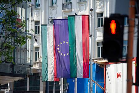 Flaggen von Ungarn und der Europäischen Union hängen an einer Fassade in Budapest.