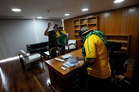 Bolsonaro-Anhänger wühlen sich in einem Büro des Palacio do Planalto, dem offiziellen Sitz des brasilianischen Präsidenten, durch Papiere.