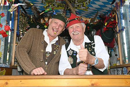 Die Vogelpfeifer Tobi und Horst Berger lachen in ihrem Stand beim Start des 187. Münchner Oktoberfests. Das größte Volksfest der Welt lockte vor der Pandemie regelmäßig rund sechs Millionen Besucher auf die Theresienwiese.