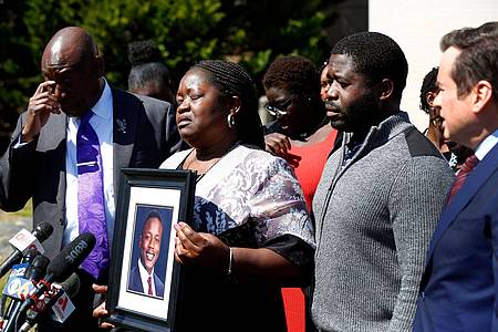 Caroline Ouko mit einem Porträt ihres getöteten Sohnes Irvo Otieno. Neben ihr stehen ihre Anwälte und ihr älterer Sohn Leon Ochieng.