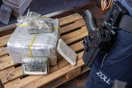 Ein Zollbeamter steht neben einem Teil der zur bislang größten Einzelsicherstellung von Kokain in Bayern.